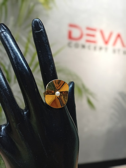 anillo con forma de disco con una perla en el centro